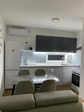 Modern kitchen with a dining table and built-in appliances. - image 11