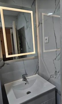 Modern bathroom with a sink and a backlit mirror. - image 8
