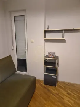 Manja soba sa kaučom, policom i balkonskim vratima. - image 16