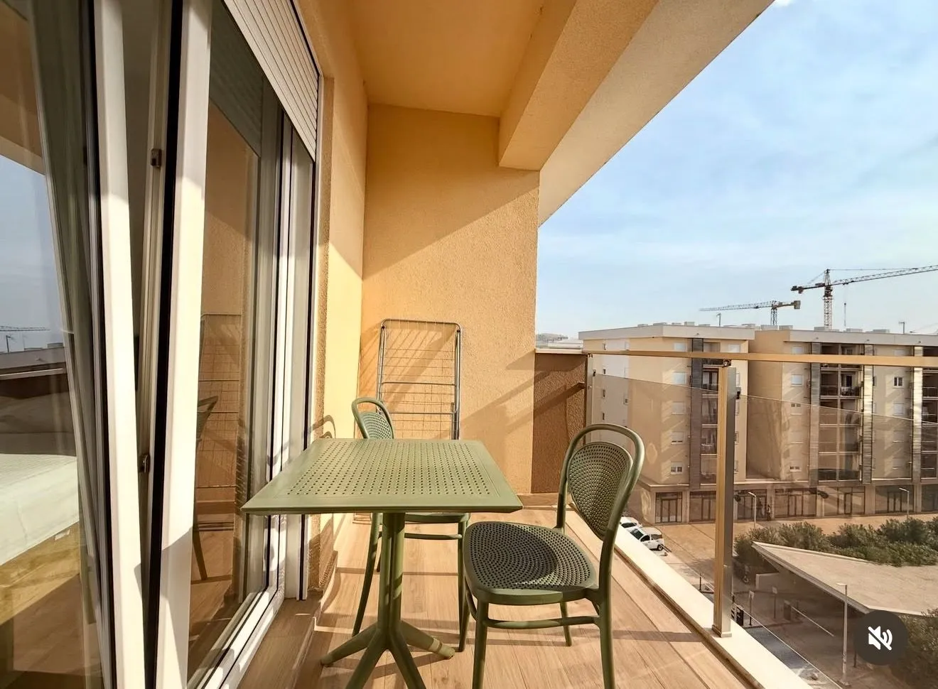 Natkriveni balkon sa garniturom za sjedenje i pogledom na okolne zgrade.