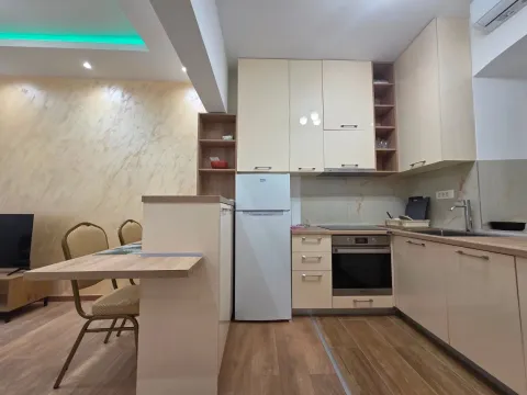 Modern kitchen with light cabinetry and a dining area. - image 4