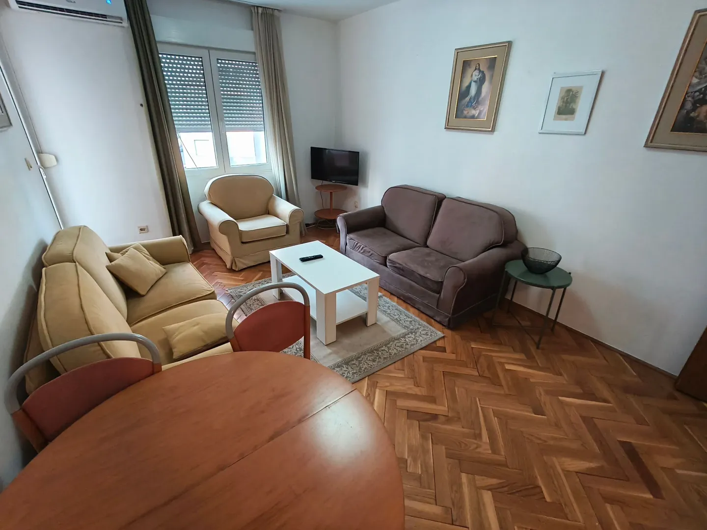 Living room with a sofa, armchair, coffee table, and dining table.