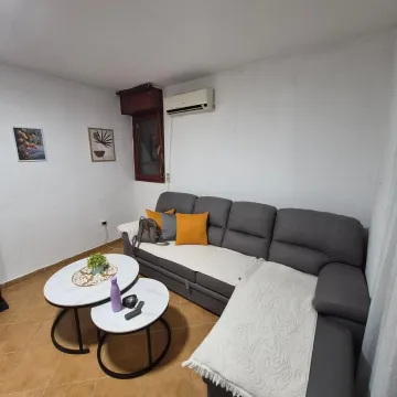 Living room with a grey sectional sofa and small round coffee tables. - image 8