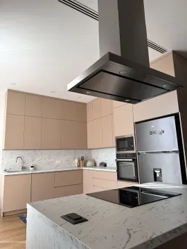 Modern kitchen with beige cabinets, marble countertops, and built-in appliances. - image 23
