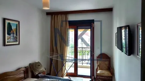 Spavaća soba sa krevetom, TV-om i izlazom na terasu. - image 10