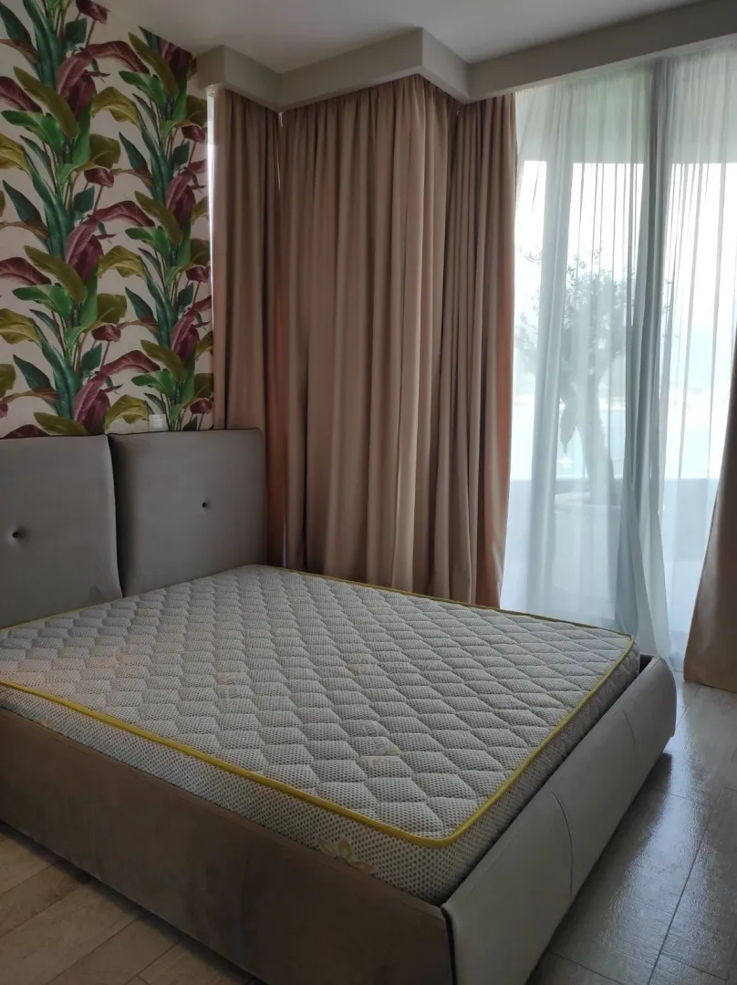 Bedroom with a double bed, wallpaper, and access to the terrace.