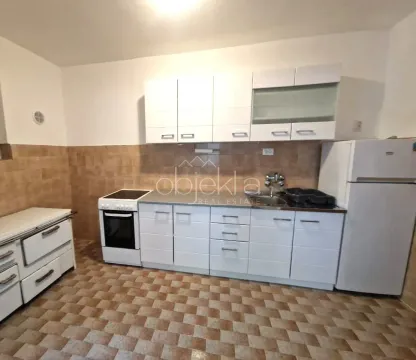 Kitchen with white cabinetry, stove, and refrigerator. - image 9
