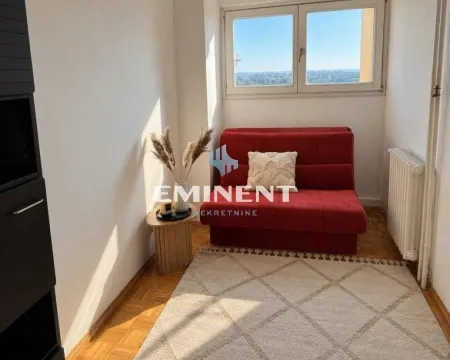 Small room with a red sofa and a window. - image 6