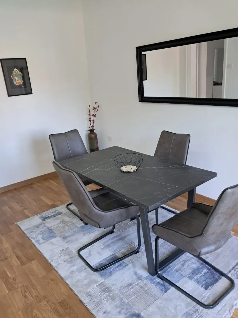 Dining table with four chairs in a bright room.