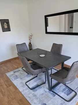 Dining table with four chairs in a bright room. - image 2