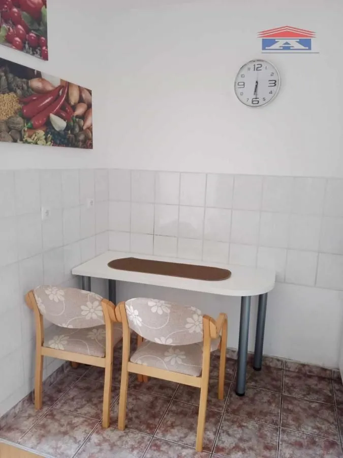 Trpezarijski deo sa stolom i dve stolice u kuhinji.