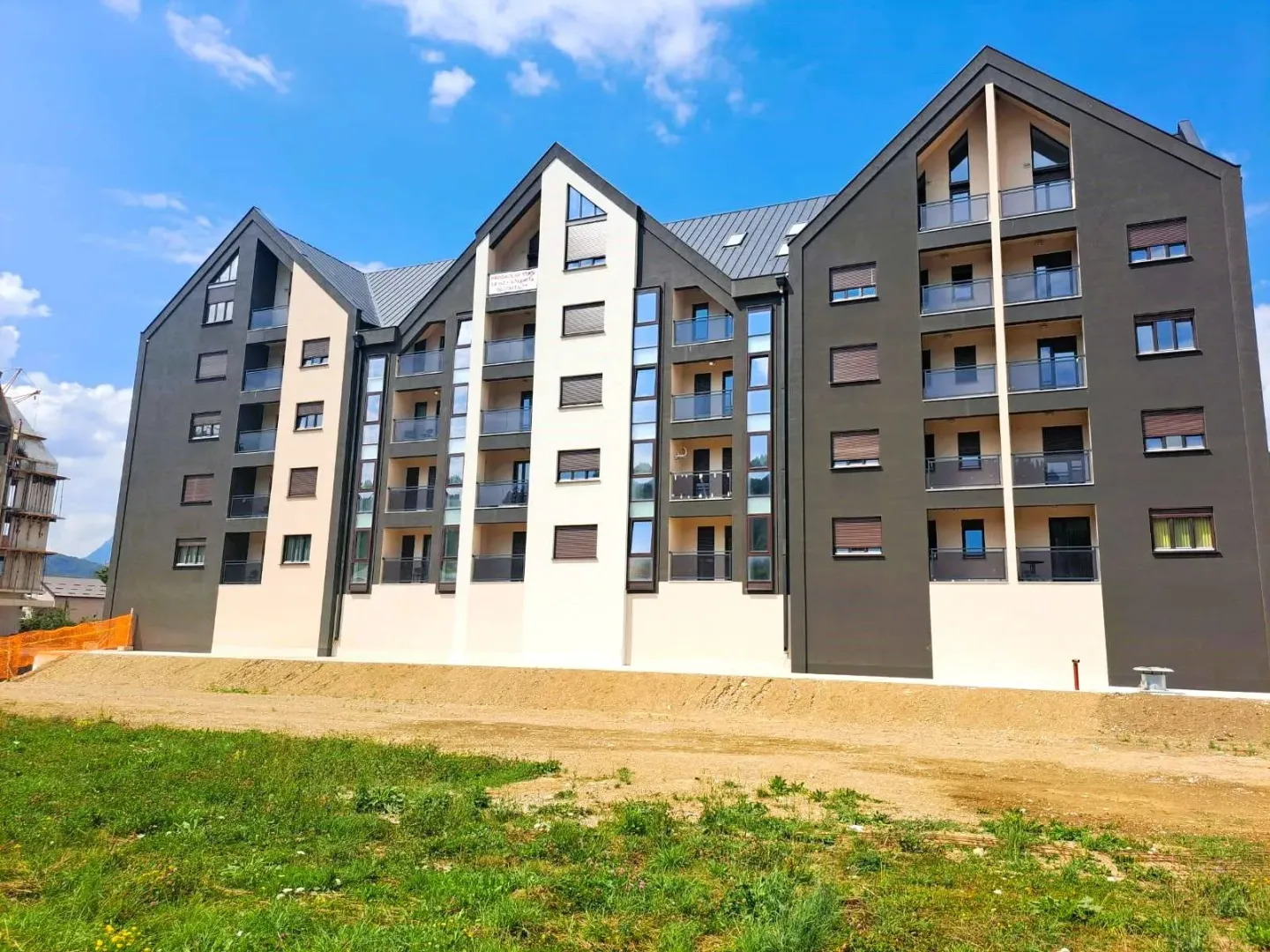 Spoljašnji izgled moderne višespratnice sa balkonima i uređenim okruženjem.