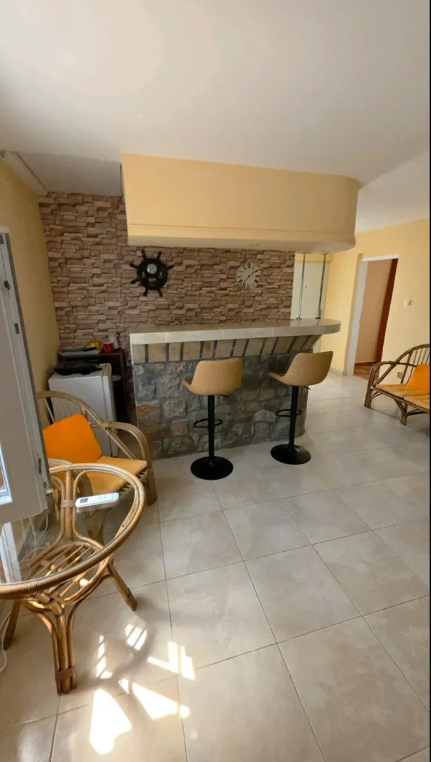 Living room with a bar counter and seating furniture.