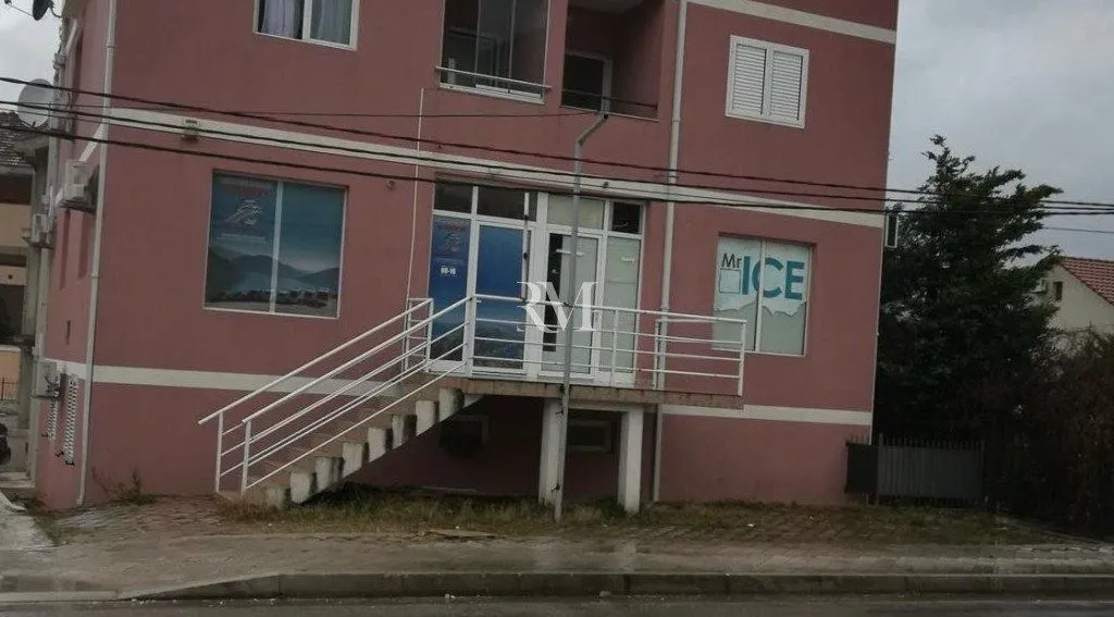 Exterior view of a commercial building with stairs and an entrance.