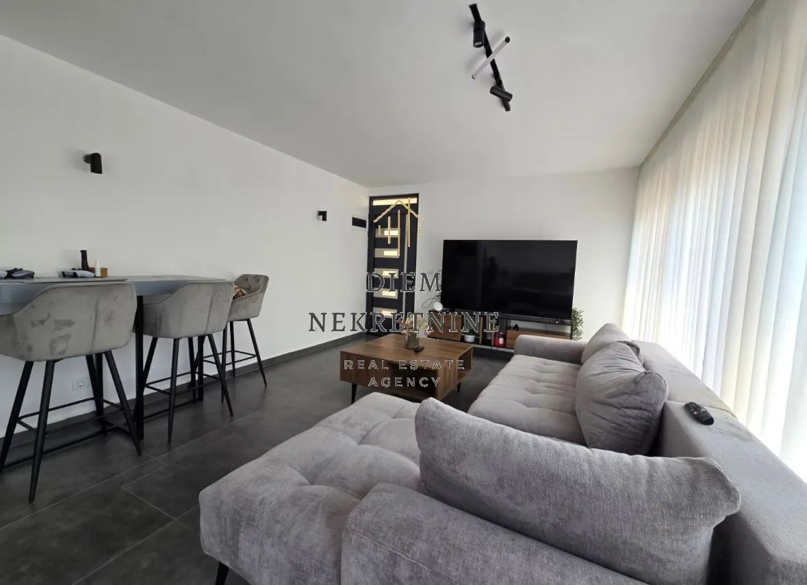 Modern living room with a sofa and dining area.