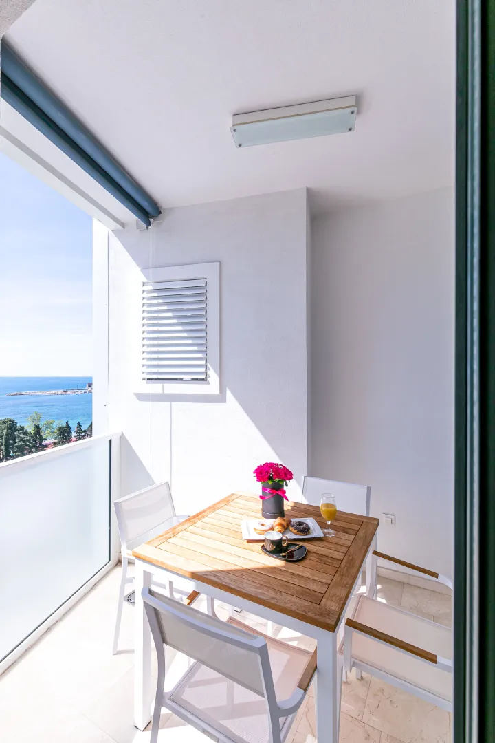 Bright terrace with a dining table and sea view.