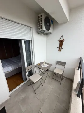Furnished balcony with seating set and a view into the room interior. - image 8