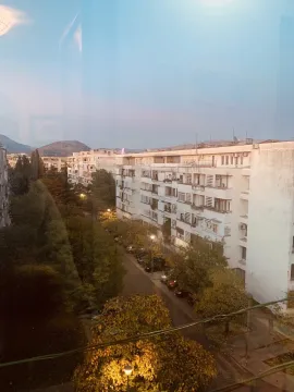 A view from the apartment of surrounding buildings and trees at dusk. - image 11