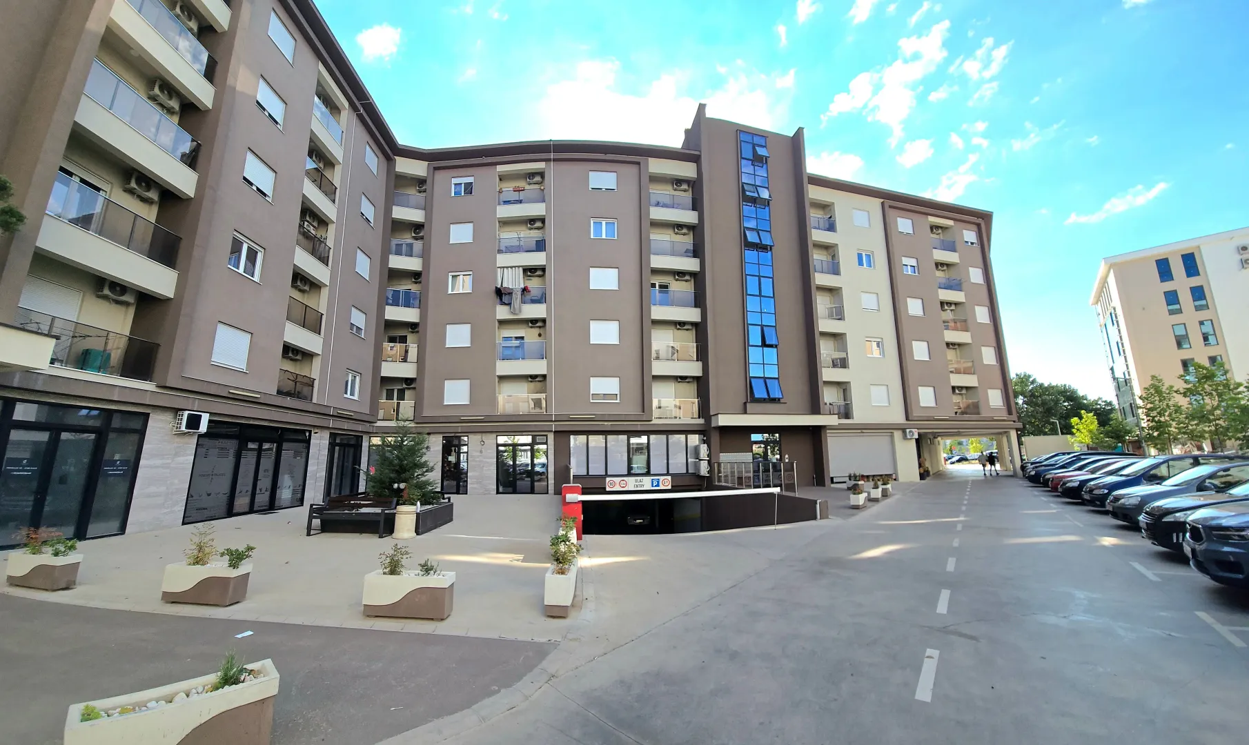 Exterior of a residential building with parking and courtyard.