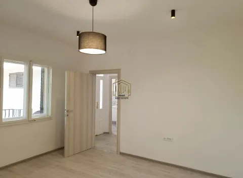 Empty room with light laminate flooring, a pendant light, and an open door leading to the hallway. - image 13