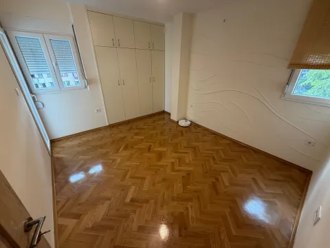 Prazna soba sa parketom, ugradnim plakarom i prozorima. - image 9