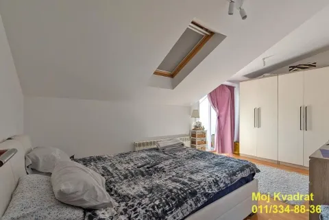 Attic bedroom with a double bed, wardrobe, and a skylight. - image 9