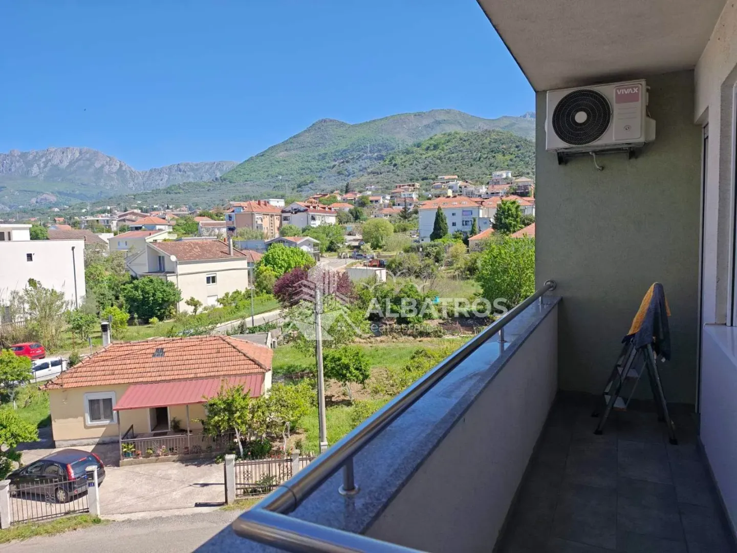 Pogled sa balkona na naselje i okolne planine.