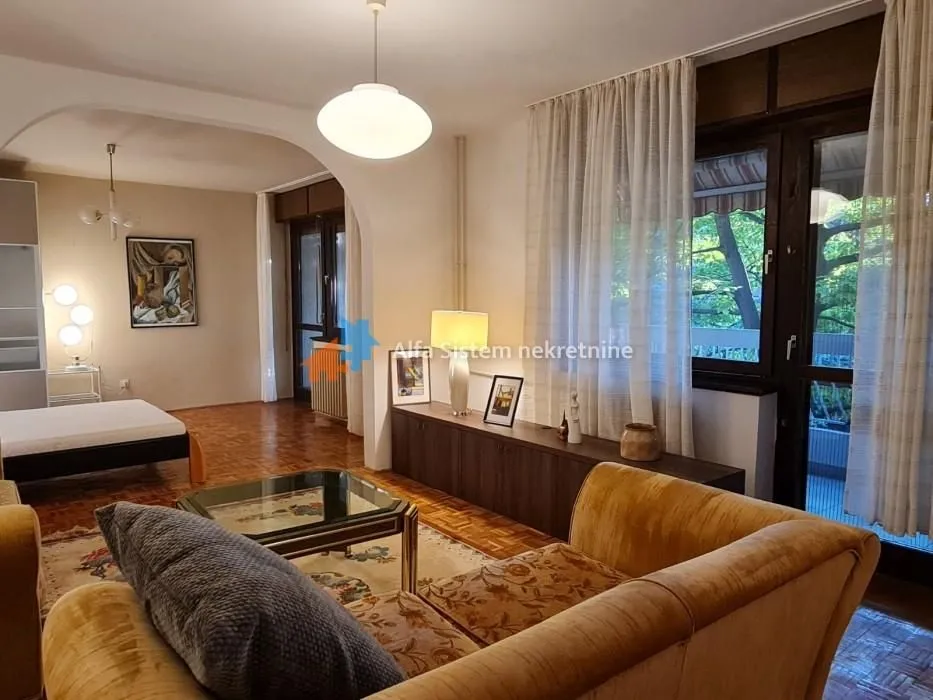 Spacious living room with sofa set, parquet flooring, and access to the terrace.