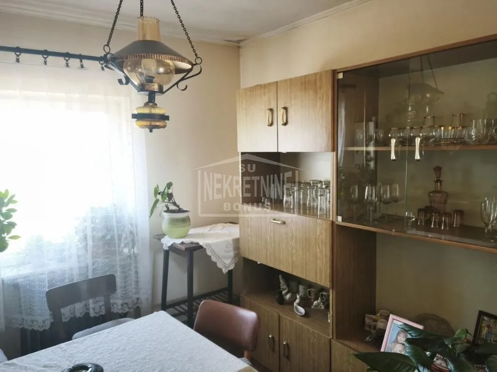 Dnevna soba sa trpezarijskim stolom i drvenim nameštajem.