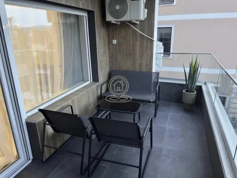 Nameštena terasa sa garniturom za sedenje i staklenom ogradom. - image 5