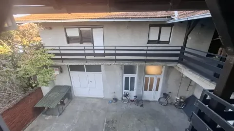 Pogled sa sprata na dvorište i fasadu kuće sa balkonom. - image 5