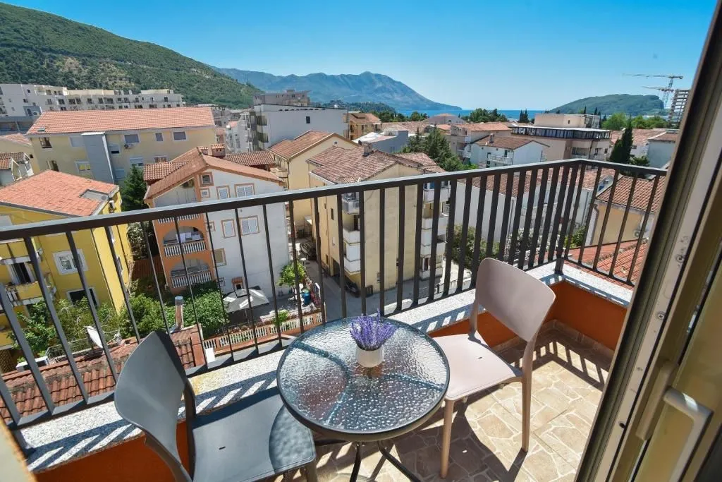 Furnished balcony with outdoor seating and a view of the city and sea.
