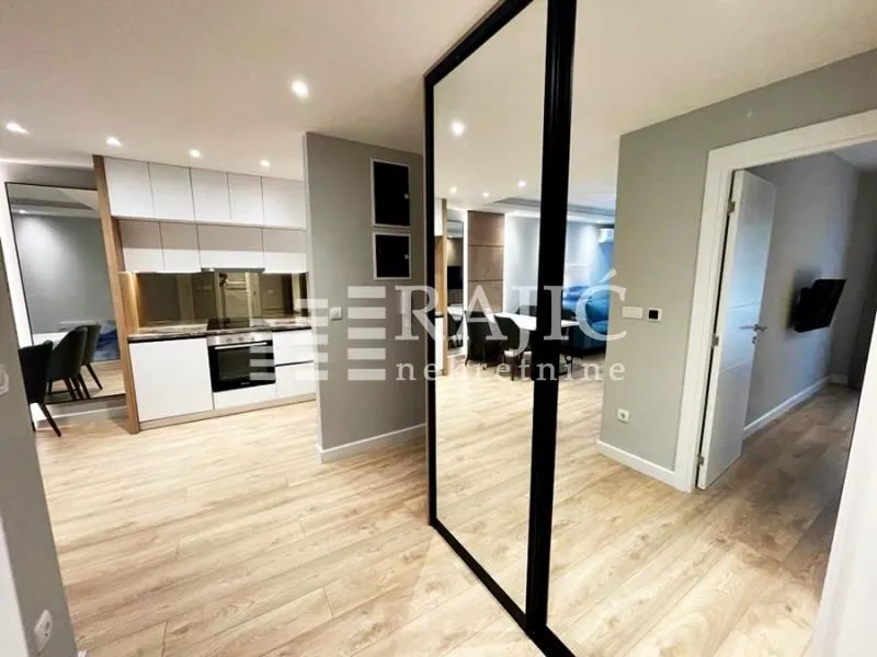 Modern kitchen with white units and a dining area in an open space layout.