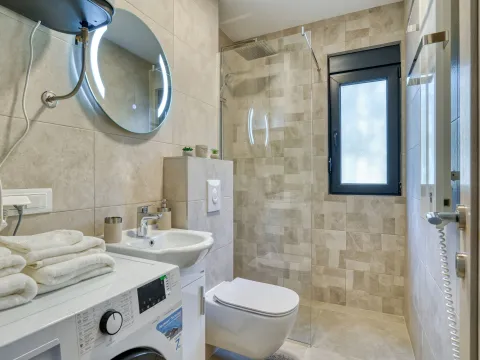 Moderno opremljeno kupatilo sa umivaonikom, tuš kabinom i veš mašinom. - image 19