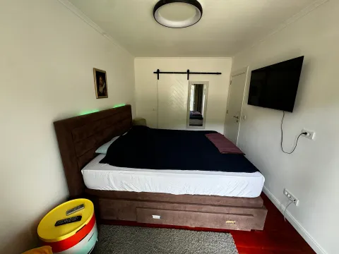 Namještena spavaća soba sa bračnim krevetom i televizorom na zidu. - image 13