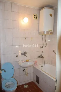 Manje kupatilo sa kadom, umivaonikom i wc šoljom obloženo keramičkim pločicama. - image 9