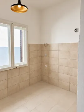 Empty kitchen space with tiled walls and floor. - image 7