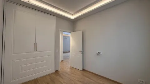 Empty room with a built-in wardrobe and wooden flooring. - image 7