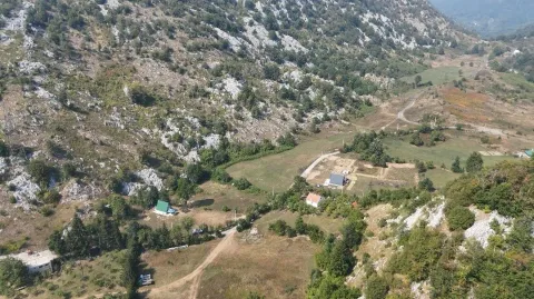 Pogled iz vazduha na planinski predio i seosko imanje sa kućama. - image 9