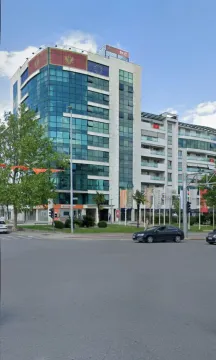 Spoljašnji izgled moderne poslovno-stambene zgrade sa staklenom fasadom na gradskoj raskrsnici. - image 12