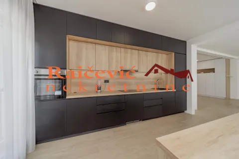 Moderna kuhinja tamnih elemenata sa drvenim detaljima i ugrađenim aparatima. - image 6