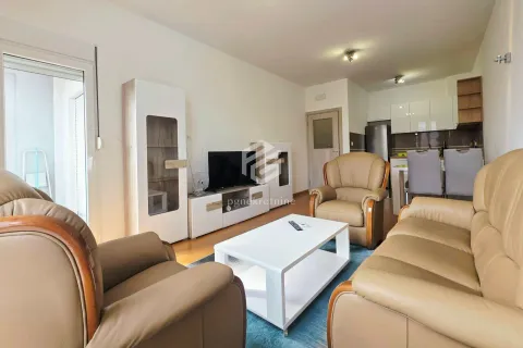 Living room with seating furniture, TV unit and a view of the kitchen. - image 2