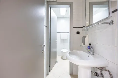 Small bathroom with a sink and a toilet in the background. - image 13