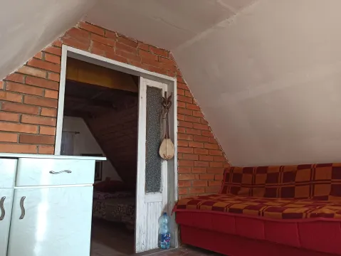 Potkrovlje sa trosedom, elementima i prolazom u drugu prostoriju. - image 14