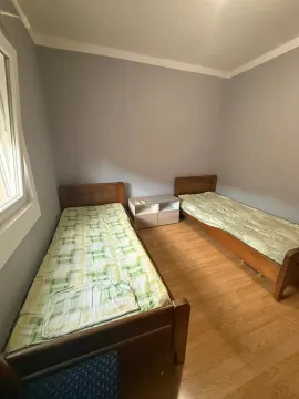 Spavaća soba sa dva drvena kreveta i noćnim stočićem. - image 11