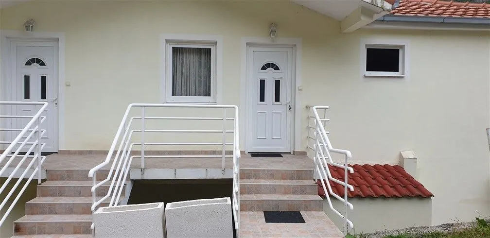Exterior view of a house featuring entrance doors and steps.