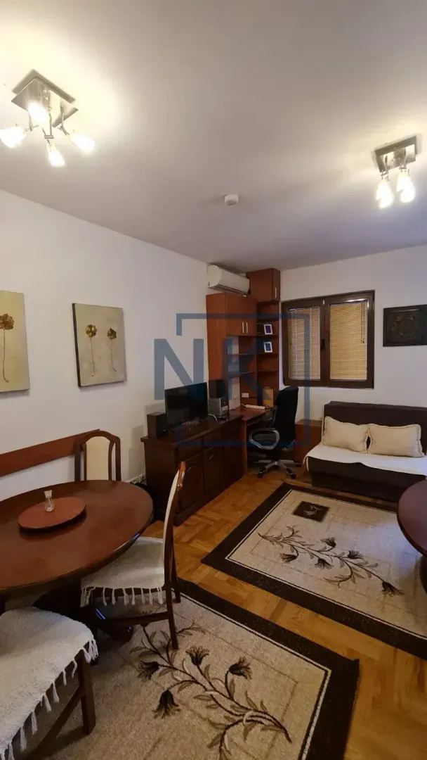 Living room with a dining table, seating furniture, and a desk.