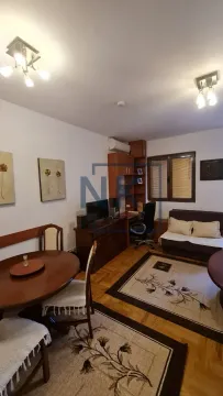 Living room with a dining table, seating furniture, and a desk. - image 3