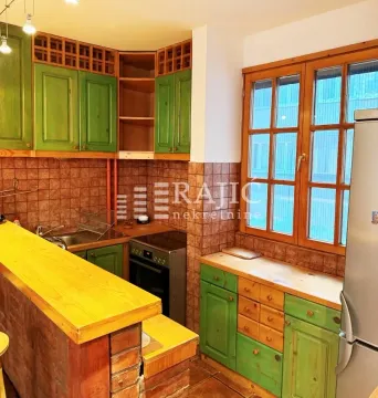 Kitchen with green wooden elements and tiled walls. - image 4