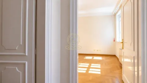 View from the hallway into an empty room with parquet flooring and white doors. - image 17